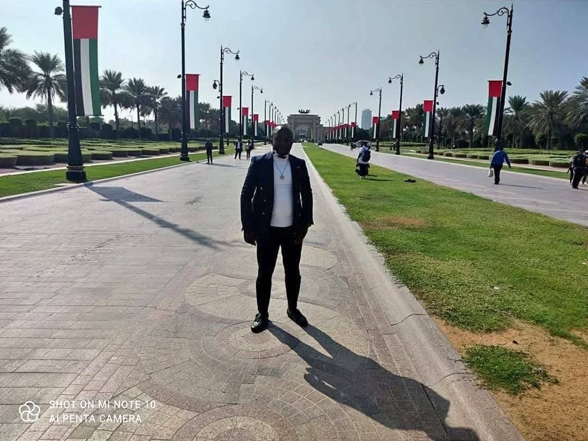 Ngala Killian standing on a palm-lined outdoor walkway